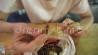 女游客在街头小吃亚洲餐馆吃蚕幼虫小吃
